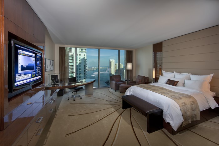 Luxury hotel bedroom with city view and desk