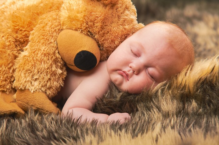 Baby sleeping with teddy bear