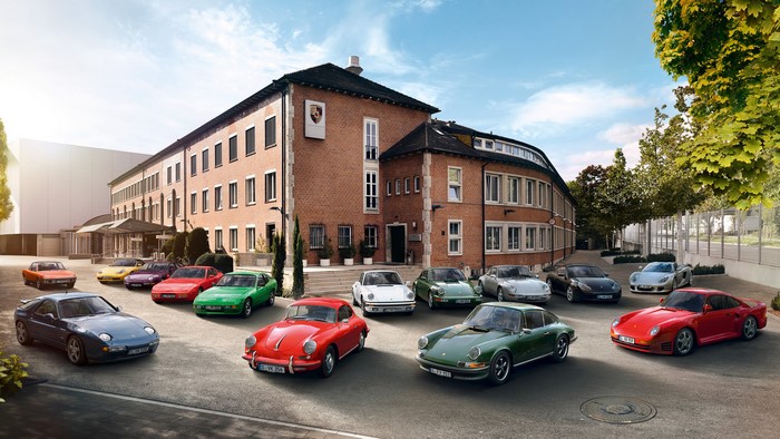 Porsche cars parked in front of a brick building