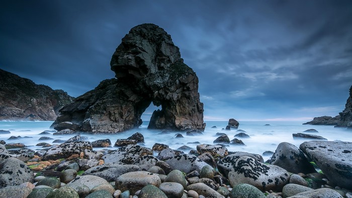 Rocky coast with sea arch and stormy sky