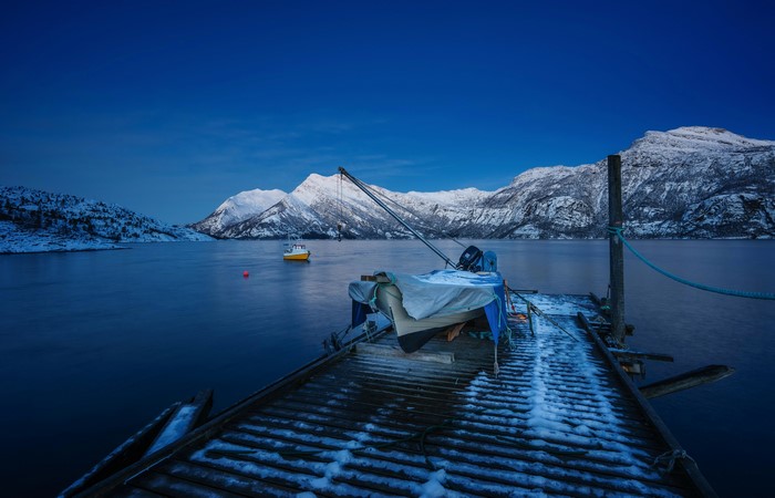 Boats docked at a pier in Norway during twilight