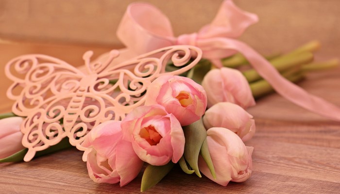 Pink tulips with a decorative butterfly and ribbon