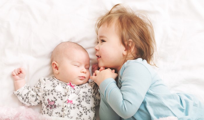 Two little girls, one infant sleeping
