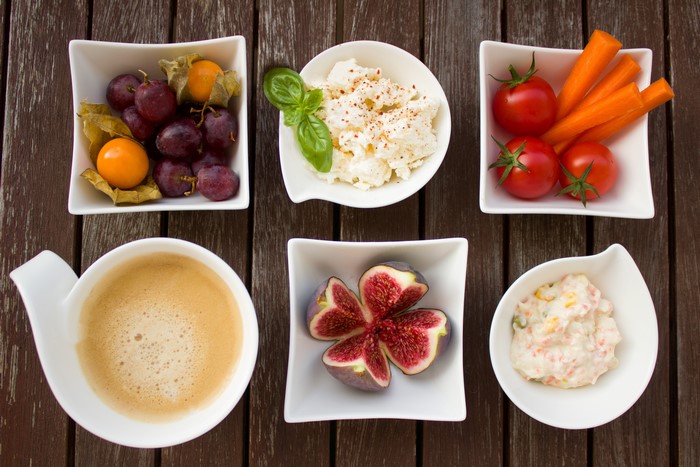 Coffee, fruits, vegetables, and salad on wooden table
