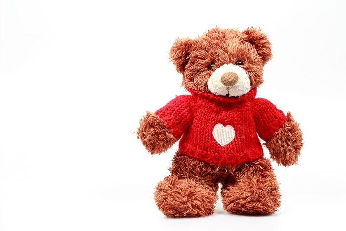 Teddy bear wearing a red sweater with a heart