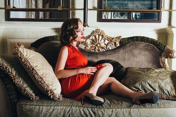 Woman in red dress sitting on a sofa