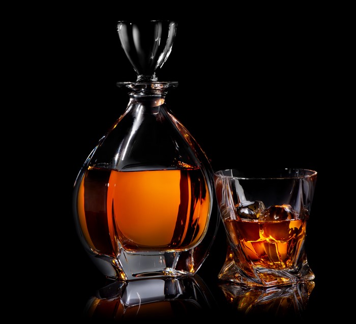Whisky in a decanter and glass on black background