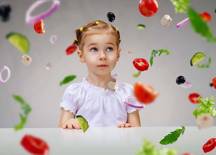 Girl looking at flying vegetables