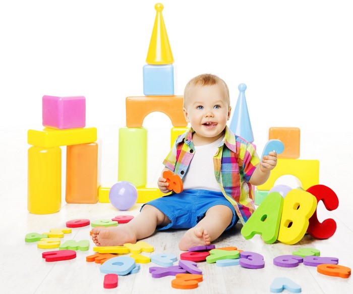 Baby playing with ABC blocks and colorful toys