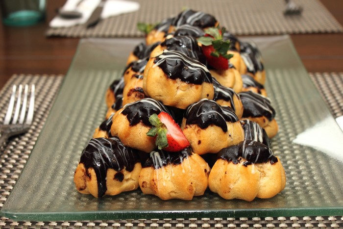Chocolate drizzled cream puffs with strawberries
