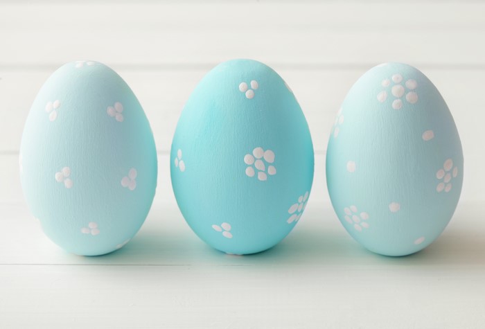 Three light blue Easter eggs with white floral patterns