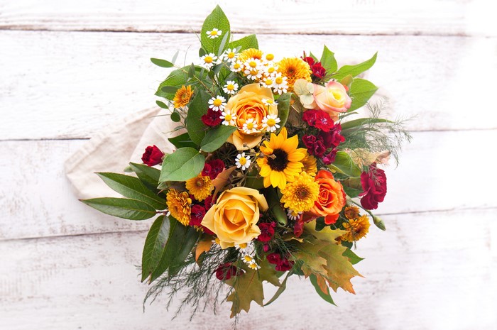 Bouquet of Roses, Sunflowers, and Daisies on Wood
