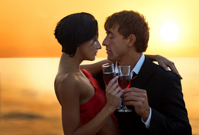 Couple with wine glasses at sunset
