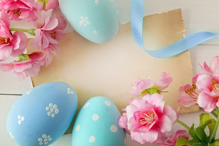Easter eggs and pink flowers on a greeting card template