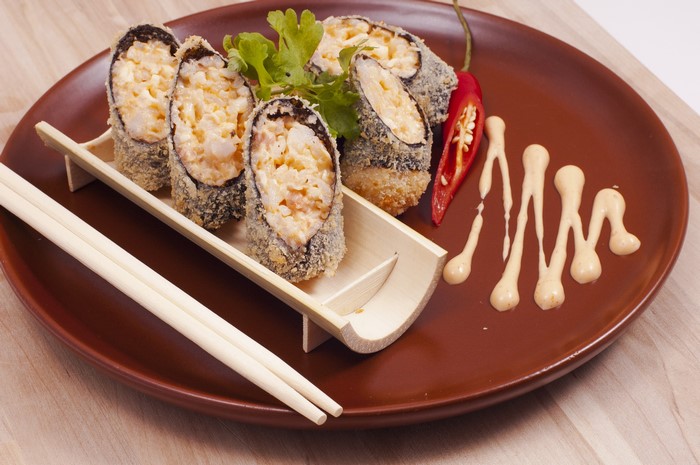 Fried sushi rolls with chili and sauce on a plate