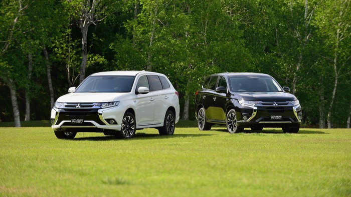 Two Mitsubishi Outlander PHEV cars on grass