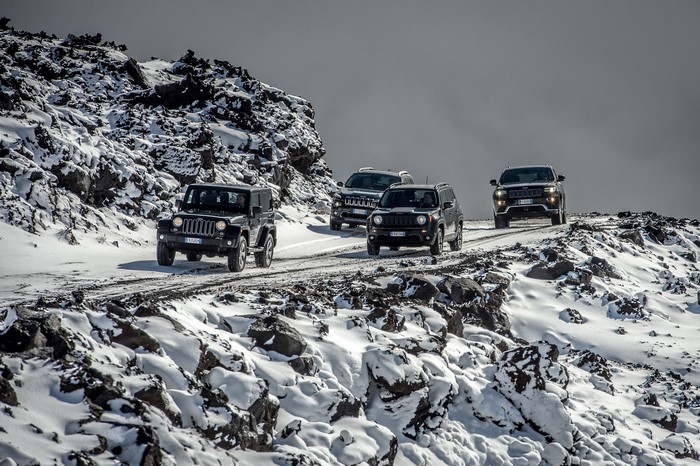 Jeeps driving on a snowy mountain road
