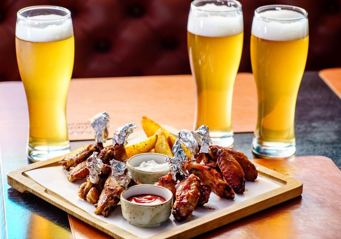 Chicken wings and beer on a wooden board