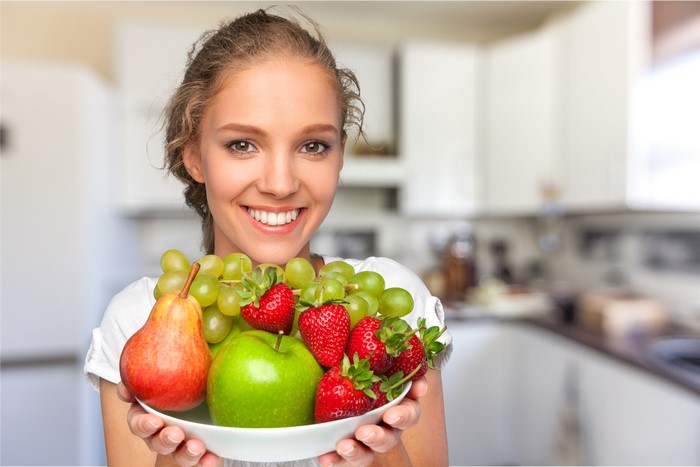 Woman holding a bowl of fruit