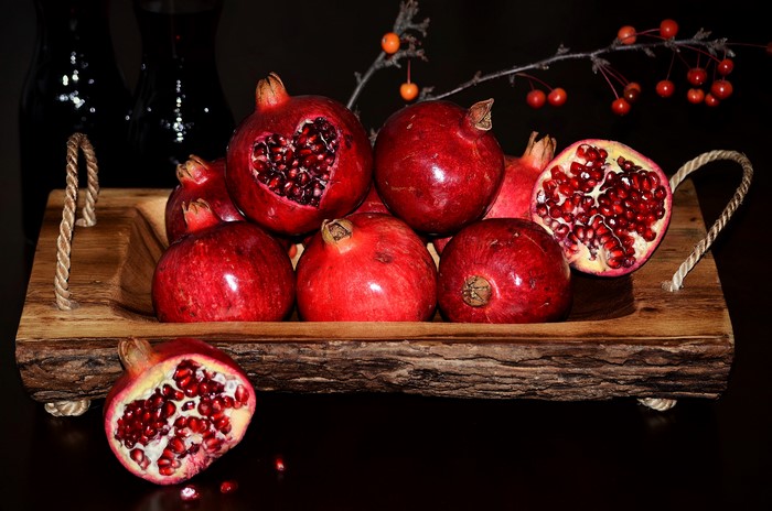 Pomegranates in a wooden bowl with a heart carved into one