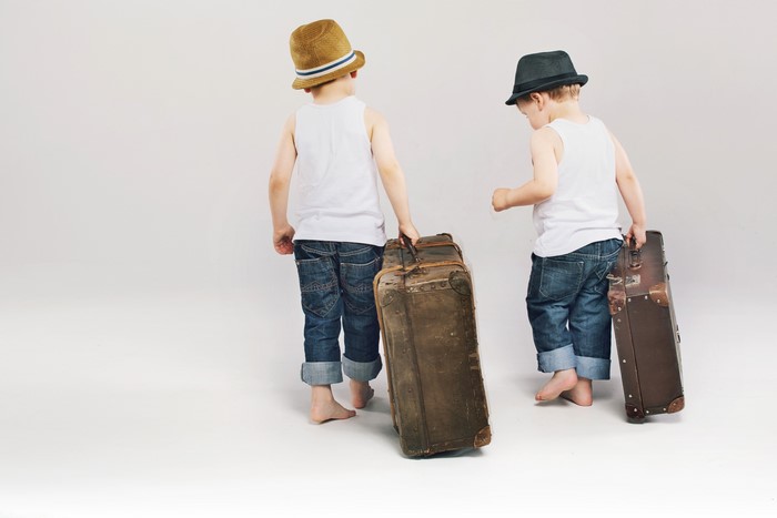 Two boys with hats and suitcases