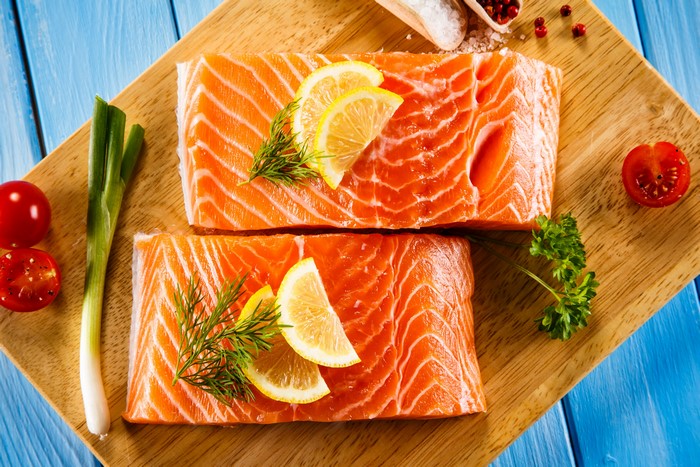 Salmon fillets with lemon and herbs on a cutting board