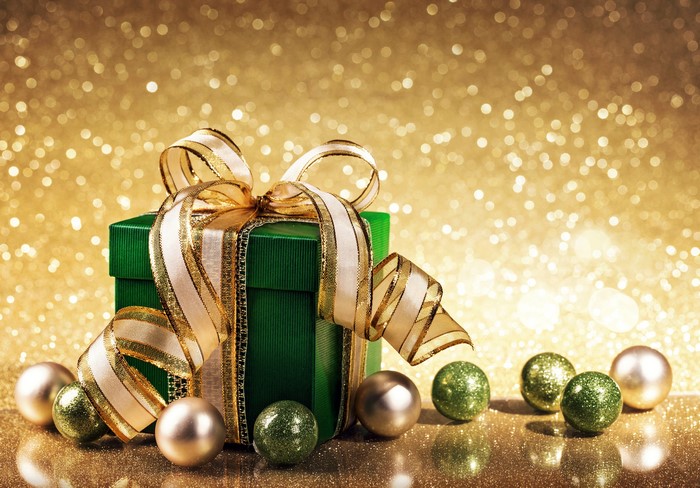 Green gift box with gold ribbon and ornaments