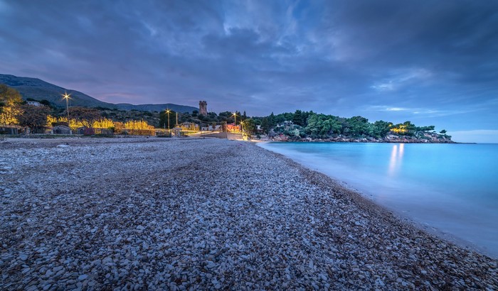 Pebble beach and calm sea at dusk in Sicily, Italy