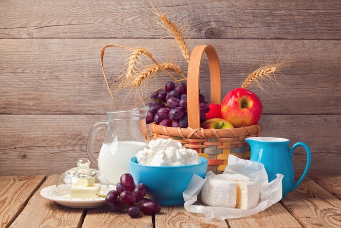 Still life with dairy products, fruits, and wheat
