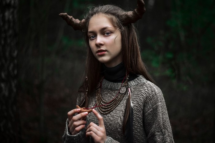 Girl with horns in a forest
