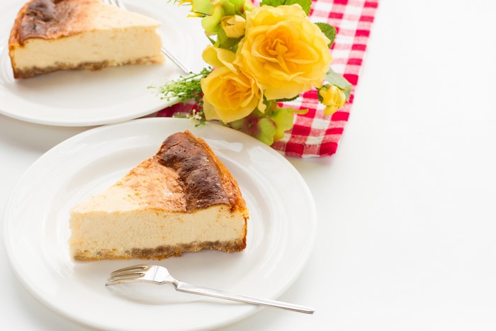 Cheesecake slices on plates with yellow roses