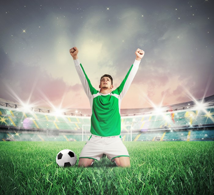 Soccer player celebrating on a stadium field