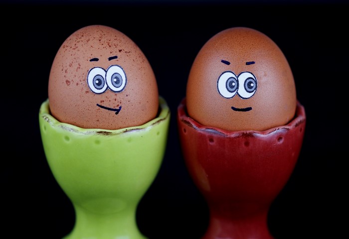 Two eggs with faces in egg cups
