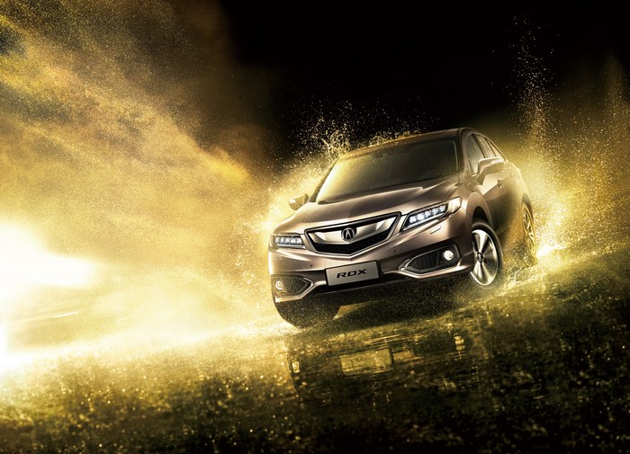 Acura RDX driving through golden water splash