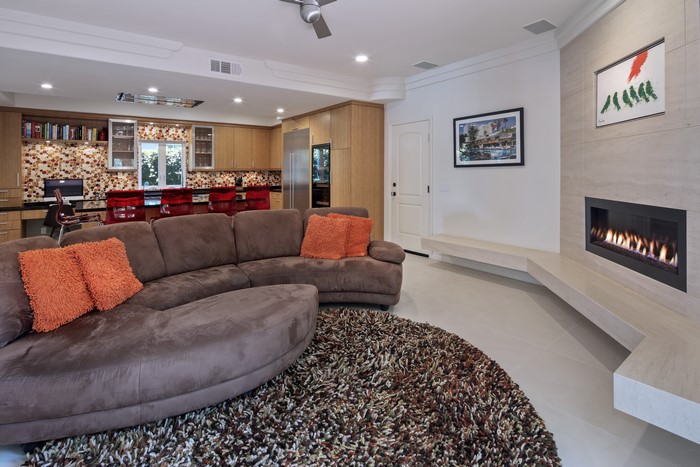 Living room with sofa, fireplace, and kitchen