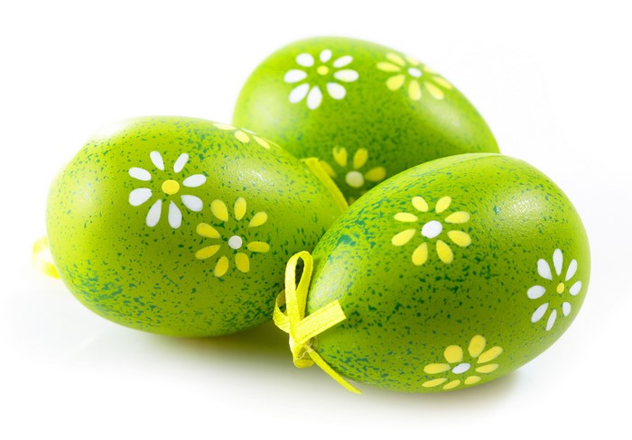 Three green Easter eggs with flowers on white background