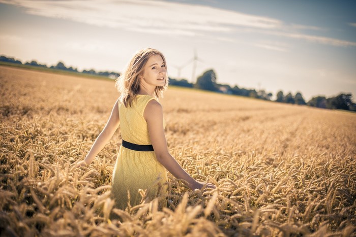 Girl in yellow dress in a wheat field