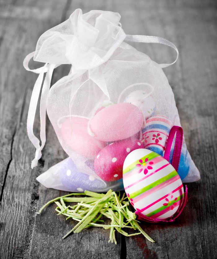 Easter eggs in a white organza bag on wood