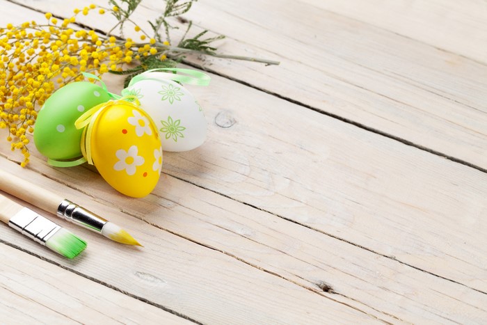 Easter Eggs and Paintbrushes on Wood Planks