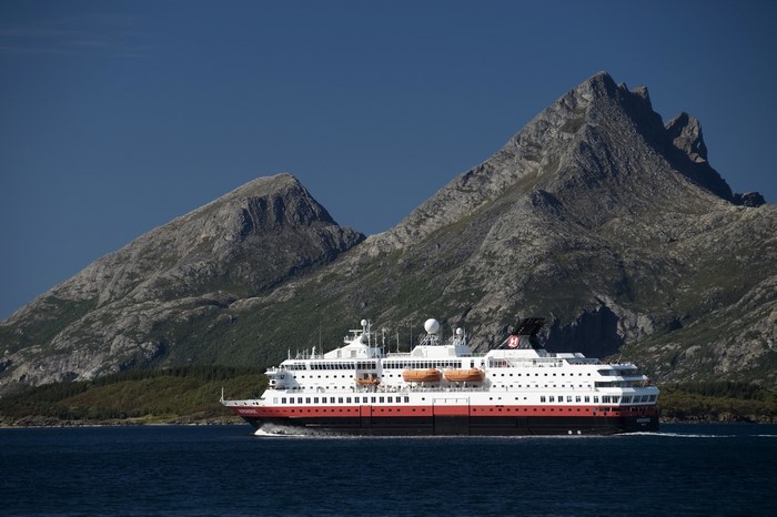 Cruise liner sailing near mountains in Norway