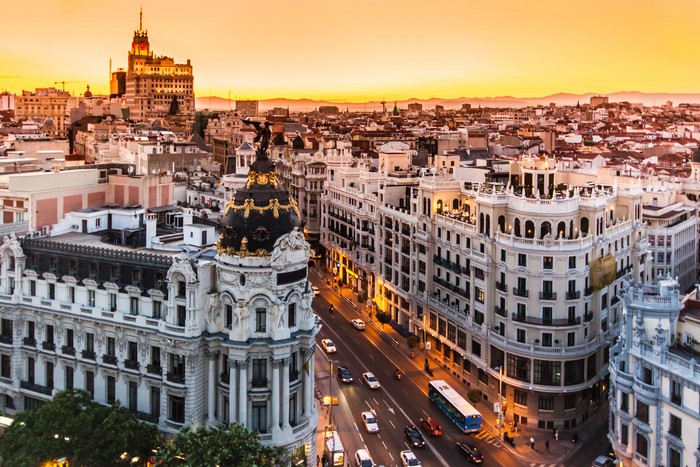 Madrid cityscape at sunset with historic buildings and street traffic