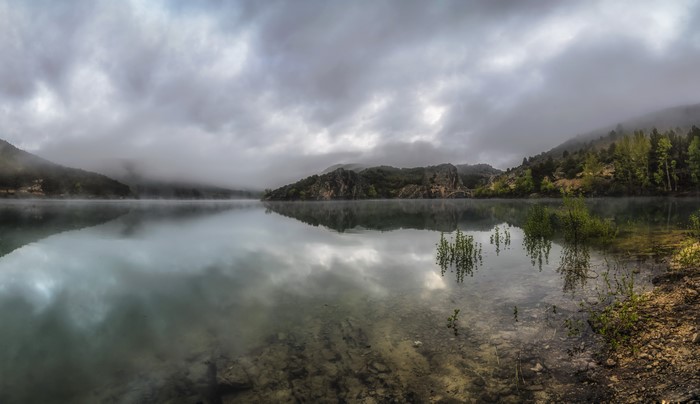 Misty lake with mountains and forest in Aragon, Spain