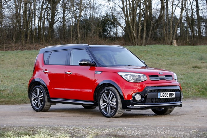 Red Kia Soul car on a dirt road