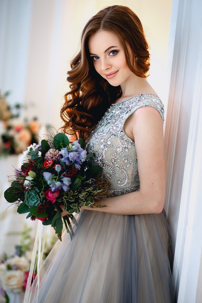 Woman in a beaded dress holding a bouquet