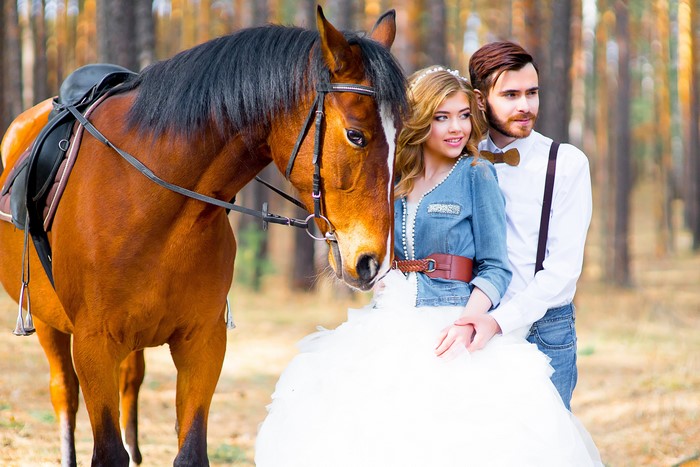 Bride and groom with a horse in a forest
