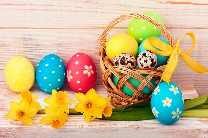 Easter eggs and daffodils on wood planks