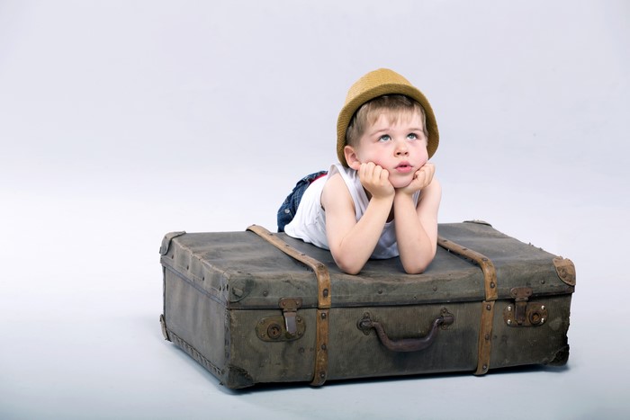 Boy in hat on suitcase
