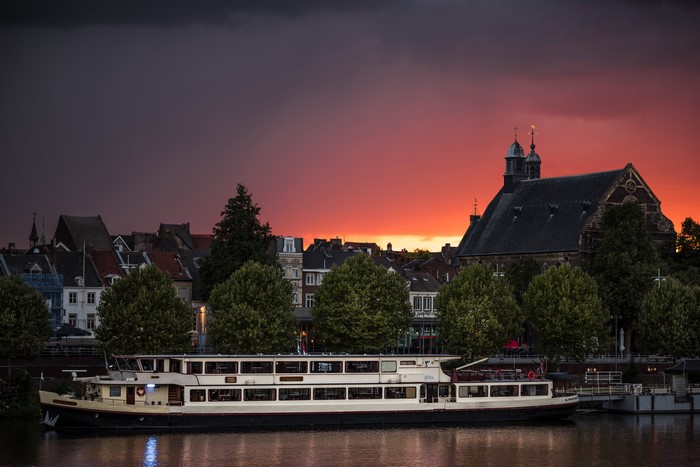 Riverboat docked in Maastricht at sunset