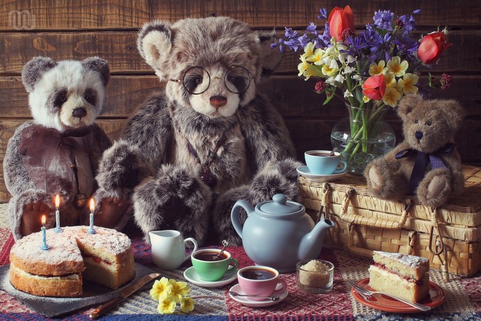 Teddy bears having a tea party with cake and flowers