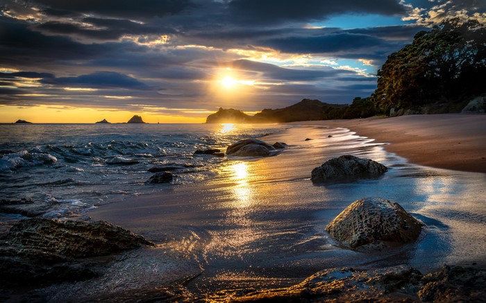 Sunset over a rocky beach in Tasman, New Zealand